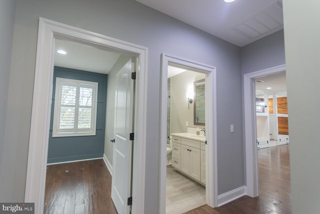 hall with sink and wood-type flooring