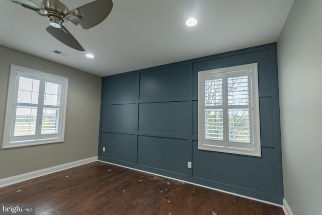 spare room featuring ceiling fan, dark hardwood / wood-style flooring, and a healthy amount of sunlight