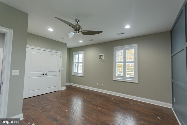 unfurnished bedroom with ceiling fan, dark hardwood / wood-style floors, and a closet