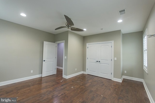unfurnished bedroom with a closet, dark hardwood / wood-style floors, and ceiling fan