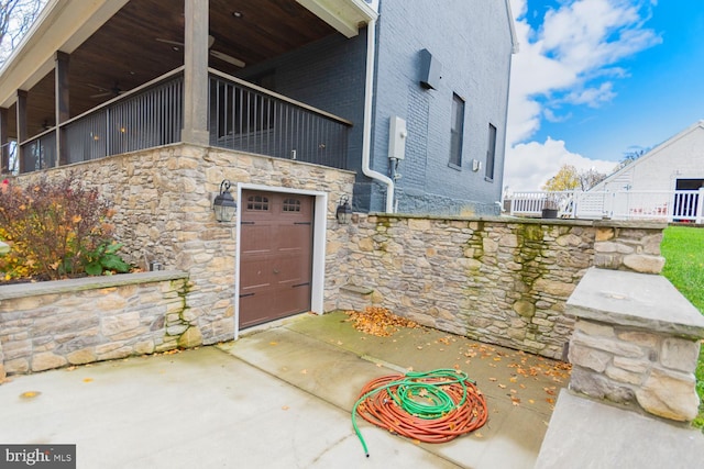 doorway to property featuring ceiling fan and a garage