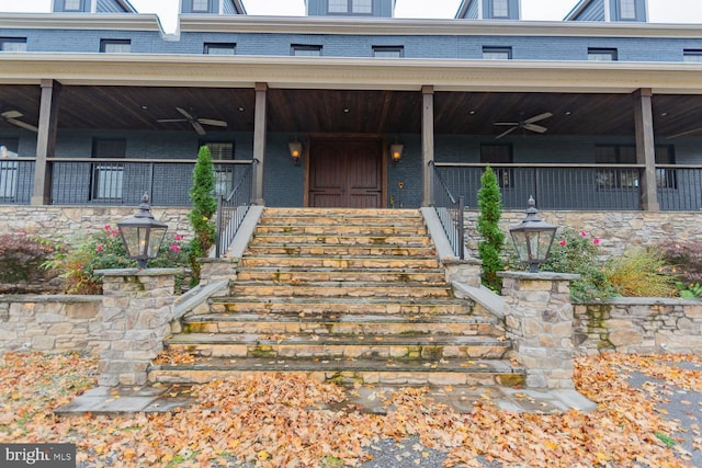 view of exterior entry with covered porch and ceiling fan