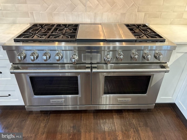 details with white cabinetry, double oven range, and dark hardwood / wood-style floors