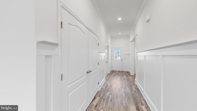 hallway featuring crown molding and light hardwood / wood-style floors