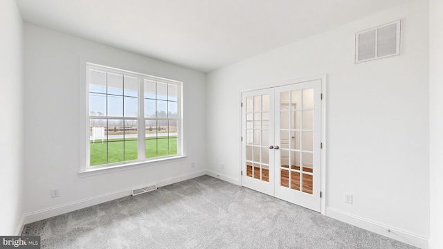 carpeted spare room with french doors