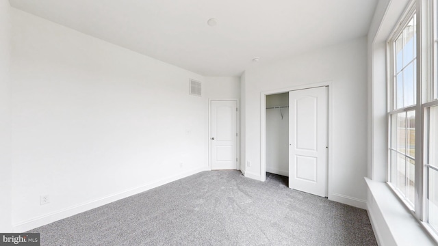 unfurnished bedroom featuring carpet and a closet