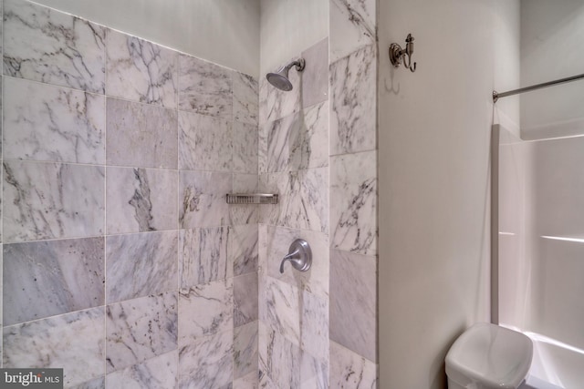 bathroom featuring toilet and tiled shower