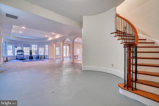 interior space featuring concrete floors and a raised ceiling