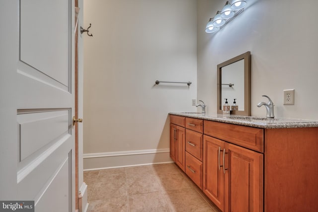 bathroom with vanity with extensive cabinet space, dual sinks, and tile floors