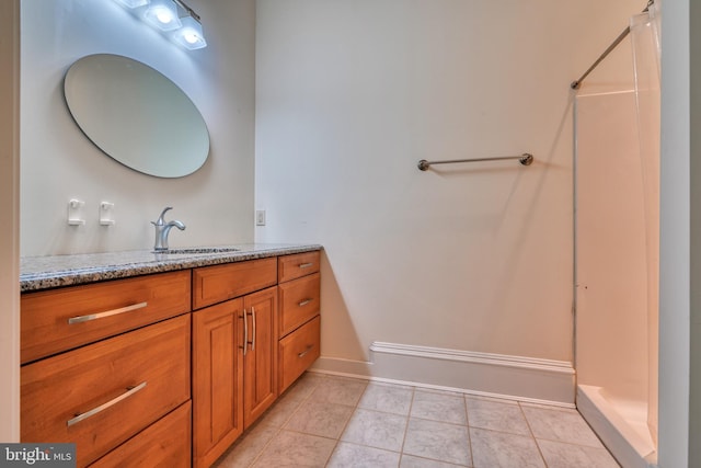 bathroom with walk in shower, tile flooring, and vanity