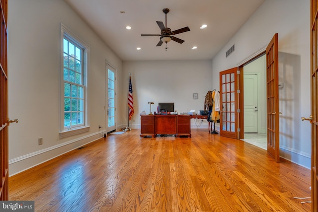 unfurnished office with ceiling fan, light hardwood / wood-style floors, and french doors