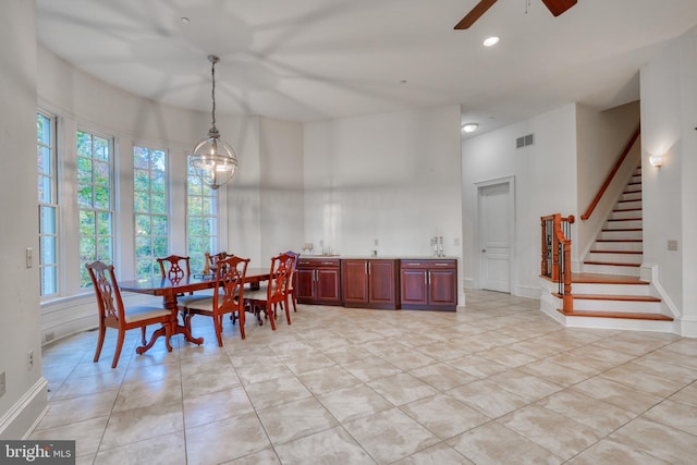 dining room featuring light tile flooring and ceiling fan with notable chandelier