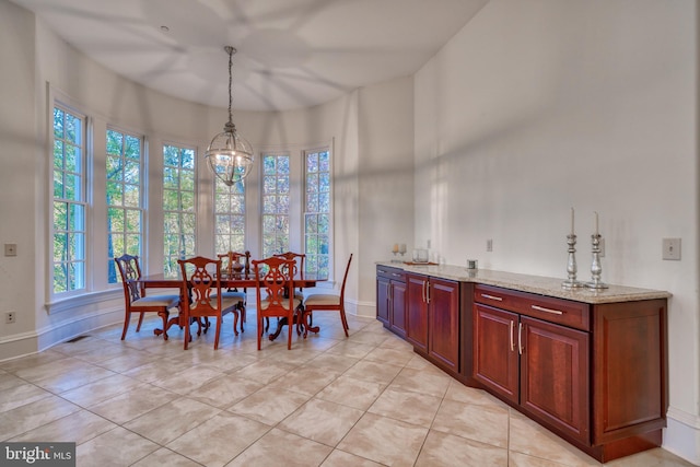 dining space featuring an inviting chandelier and light tile floors