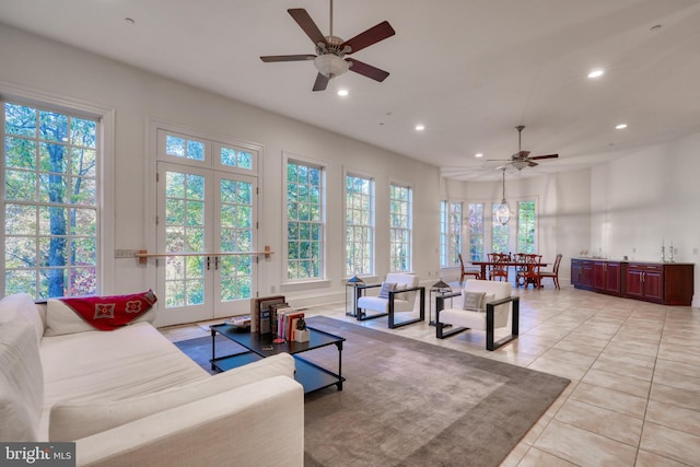 tiled living room featuring ceiling fan, a healthy amount of sunlight, and french doors