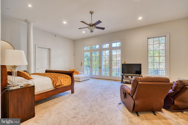 carpeted bedroom featuring ceiling fan, ornate columns, access to exterior, and french doors