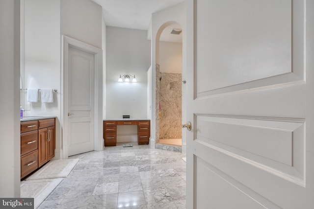 bathroom with tile flooring, walk in shower, and vanity