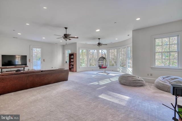 carpeted living room with ceiling fan