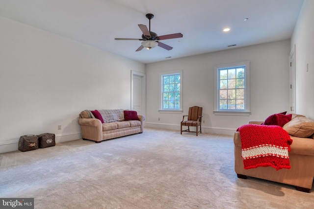 carpeted living room with ceiling fan