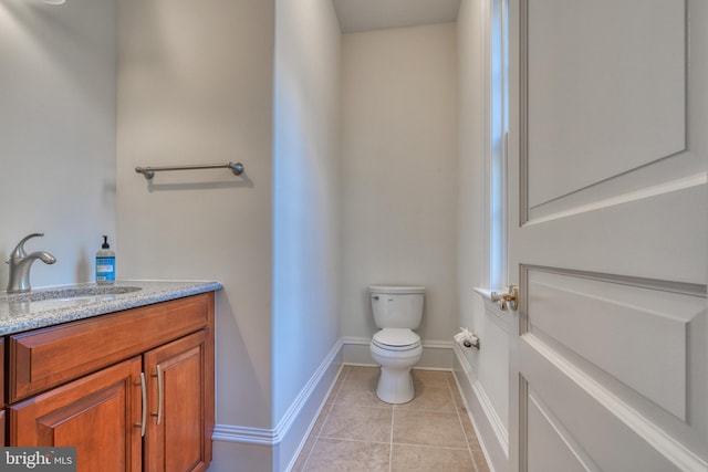 bathroom with tile flooring, toilet, and vanity