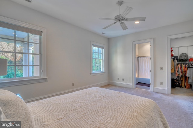 carpeted bedroom featuring a spacious closet, a closet, and ceiling fan