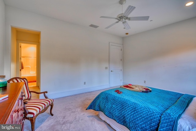 bedroom with ceiling fan, light colored carpet, and ensuite bathroom