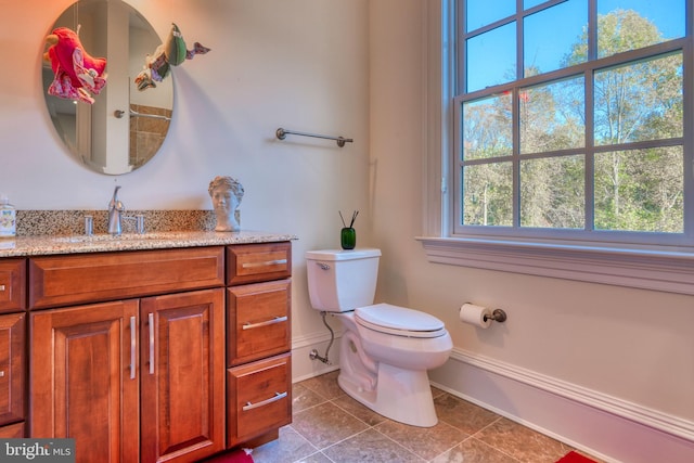 bathroom featuring toilet, vanity, and tile flooring