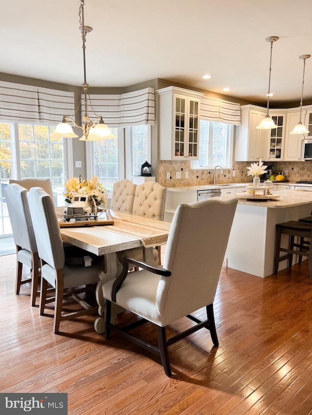 dining room featuring a chandelier, light hardwood / wood-style flooring, and a healthy amount of sunlight