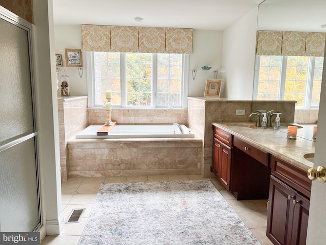 bathroom featuring tiled tub, tile patterned flooring, and vanity