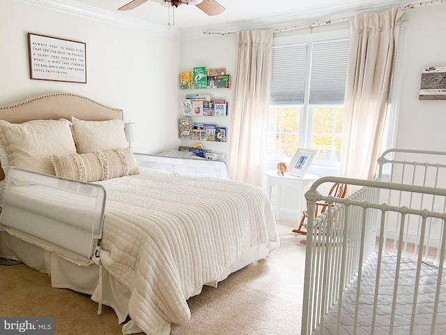 carpeted bedroom featuring ceiling fan and crown molding