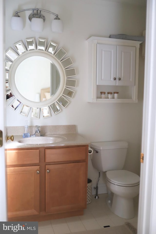 bathroom with tile patterned flooring, vanity, and toilet