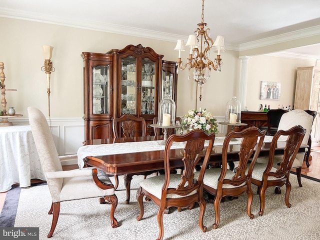 dining space featuring ornate columns, crown molding, and an inviting chandelier