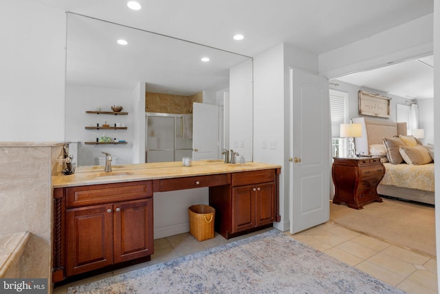 bathroom featuring tile patterned floors, vanity, and a shower with shower door