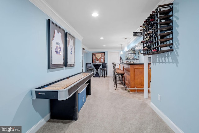 game room featuring bar area, crown molding, and light colored carpet