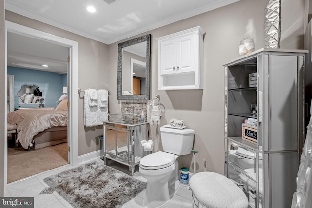 bathroom featuring tile patterned floors, toilet, and crown molding