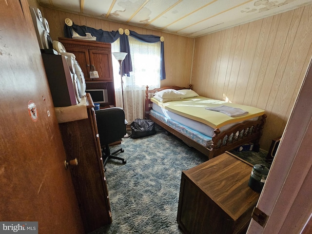 bedroom with wood walls and carpet flooring