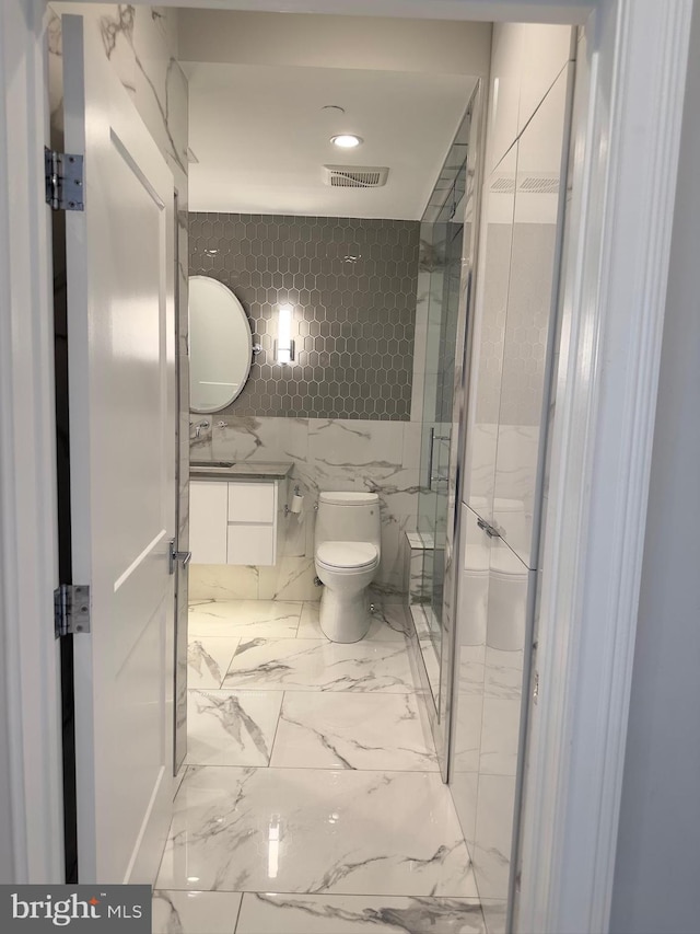 bathroom with tile walls, toilet, and tile floors