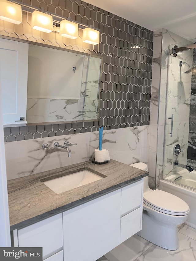 full bathroom with tile flooring, toilet, enclosed tub / shower combo, vanity, and tile walls