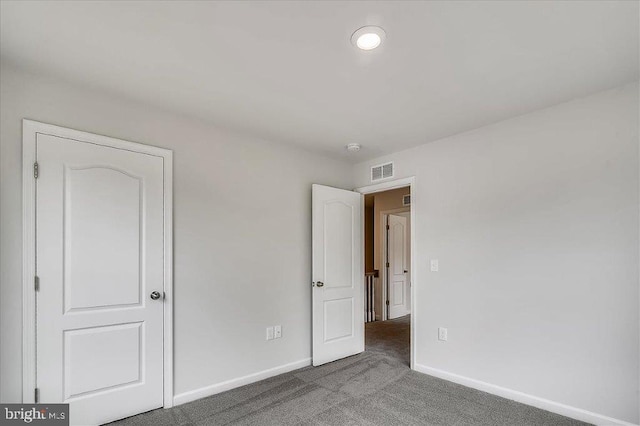 empty room with dark colored carpet