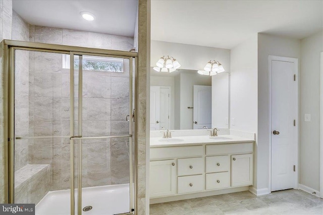 bathroom with tile floors, a shower with shower door, and double sink vanity