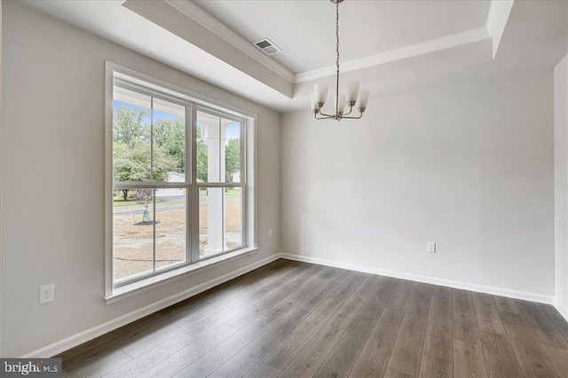 spare room featuring a healthy amount of sunlight, ornamental molding, a notable chandelier, and dark hardwood / wood-style floors