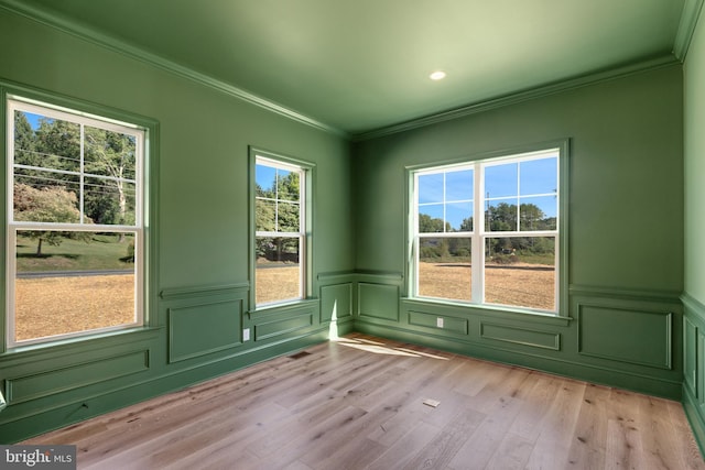 unfurnished room with light hardwood / wood-style flooring and crown molding