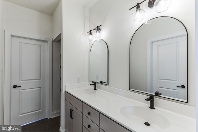 bathroom with dual sinks, large vanity, and tile flooring