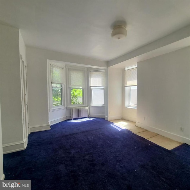 carpeted empty room with radiator heating unit