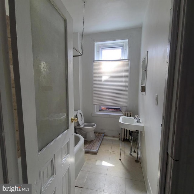 bathroom with baseboards, toilet, and tile patterned floors