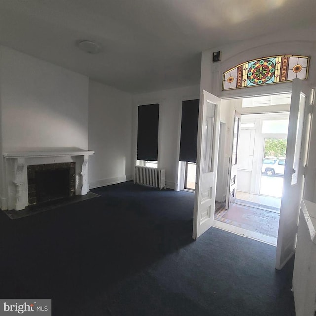 entrance foyer featuring carpet flooring and radiator heating unit