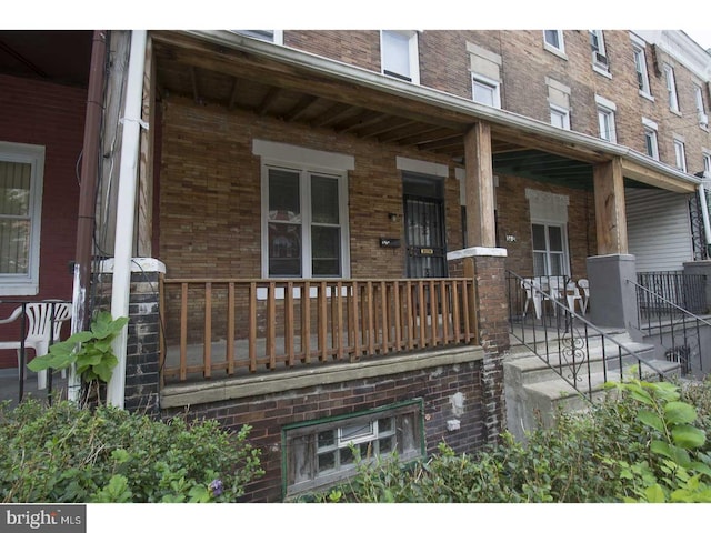 view of side of home featuring covered porch