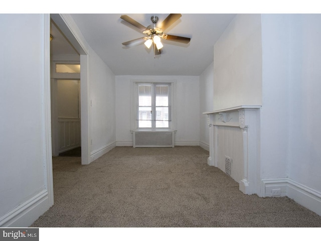 unfurnished living room featuring ceiling fan, radiator, and light colored carpet