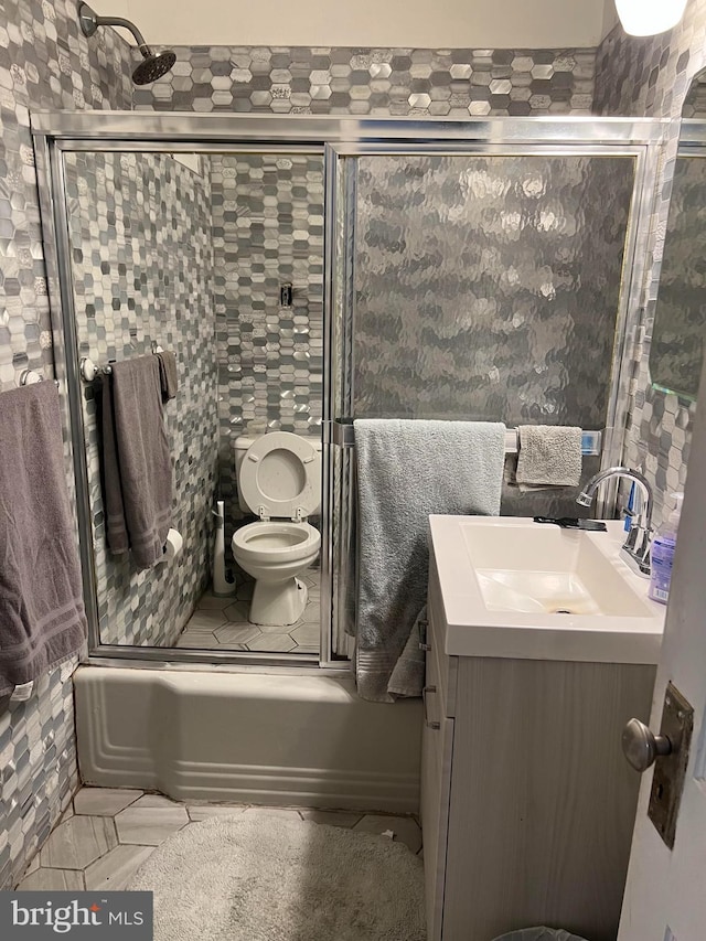 full bathroom with tile flooring, toilet, enclosed tub / shower combo, and vanity