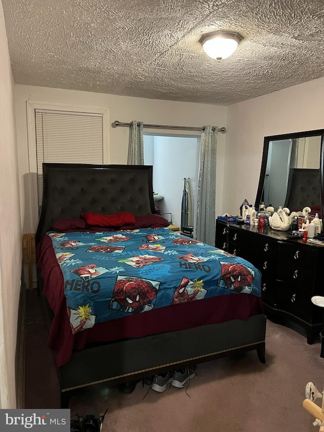 bedroom with a textured ceiling and carpet flooring