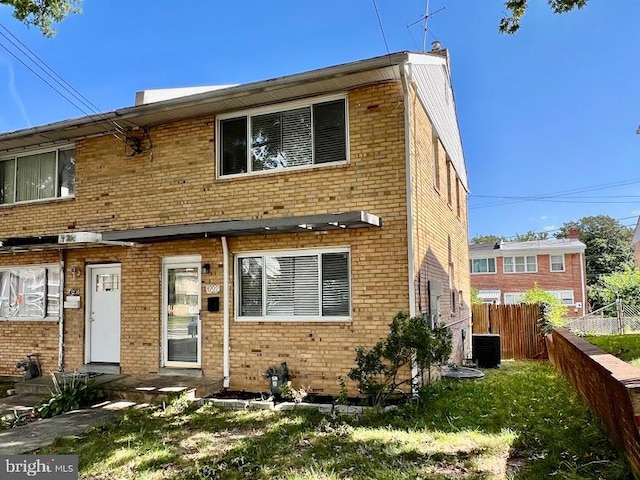 view of front of property featuring a front yard and central AC